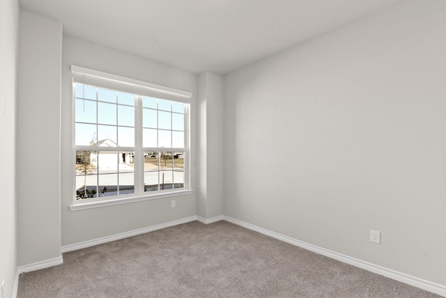 carpeted spare room featuring baseboards