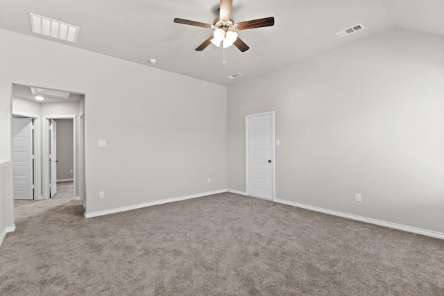 carpeted empty room with lofted ceiling, baseboards, and visible vents