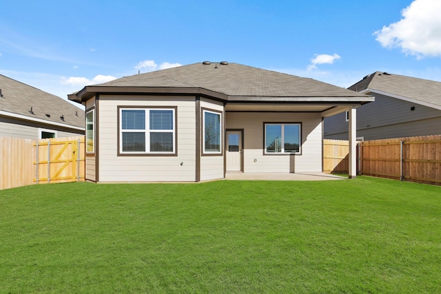 rear view of property featuring a fenced backyard, a lawn, and a patio