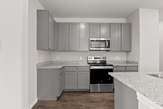 kitchen featuring dark wood-style floors, stainless steel appliances, and gray cabinets