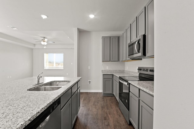 kitchen featuring dark wood-style flooring, stainless steel appliances, a sink, and gray cabinetry