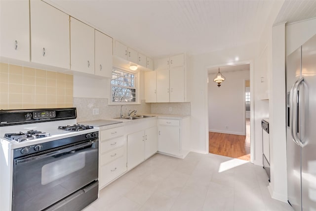 kitchen with stainless steel fridge with ice dispenser, decorative light fixtures, white cabinetry, and range with gas stovetop