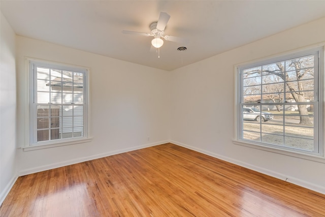 unfurnished room featuring plenty of natural light, light hardwood / wood-style flooring, and ceiling fan