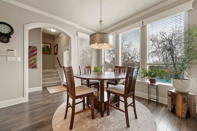 dining space featuring arched walkways, wood finished floors, and crown molding