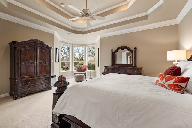 bedroom featuring light carpet, baseboards, a raised ceiling, ceiling fan, and ornamental molding