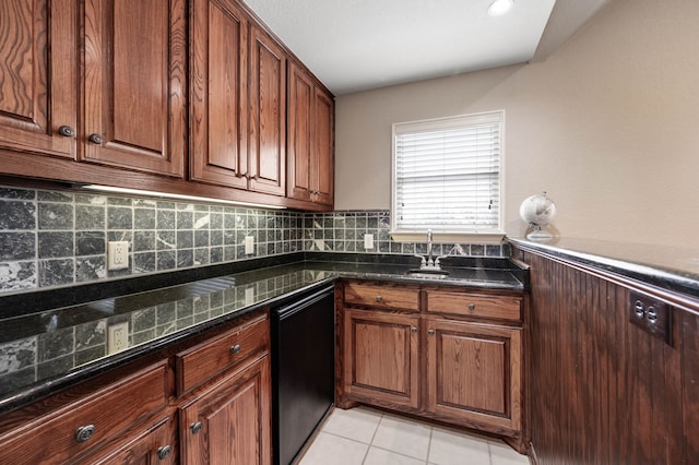 kitchen with dark stone counters, decorative backsplash, dishwashing machine, a sink, and light tile patterned flooring