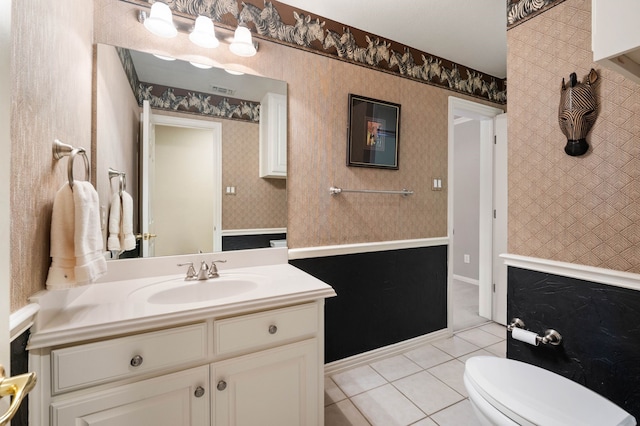 bathroom with toilet, wallpapered walls, tile patterned flooring, and vanity