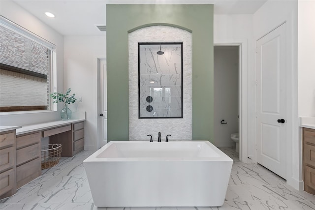 bathroom with toilet, vanity, marble finish floor, tiled shower, and a soaking tub