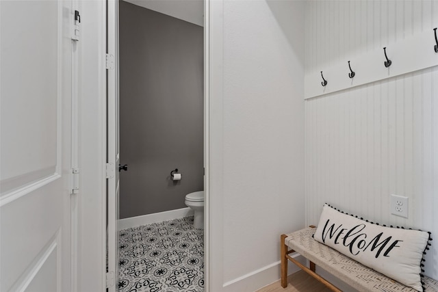 bathroom with toilet, baseboards, and tile patterned floors