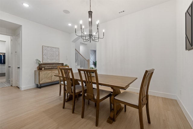 dining area with stairway, light wood-type flooring, visible vents, and baseboards