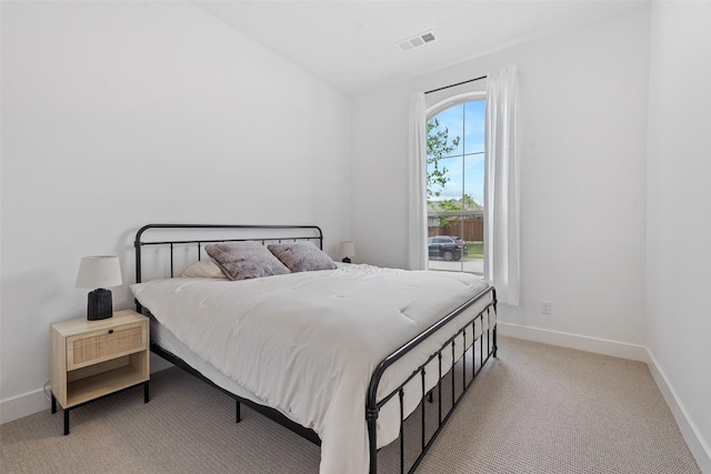 bedroom with visible vents, light carpet, and baseboards