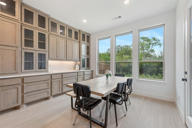 dining space with visible vents, plenty of natural light, light wood finished floors, and baseboards