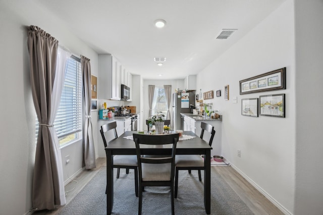 dining space featuring a healthy amount of sunlight and light wood-type flooring