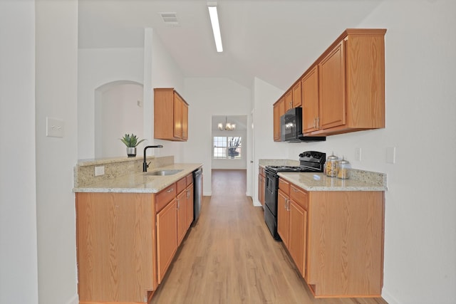 kitchen featuring light stone countertops, black appliances, sink, a notable chandelier, and light hardwood / wood-style flooring