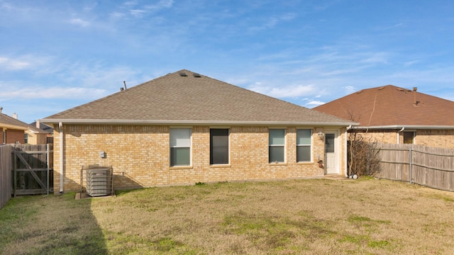 back of property featuring cooling unit and a yard