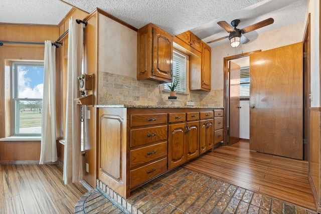 kitchen featuring a textured ceiling, ceiling fan, dark hardwood / wood-style flooring, and backsplash