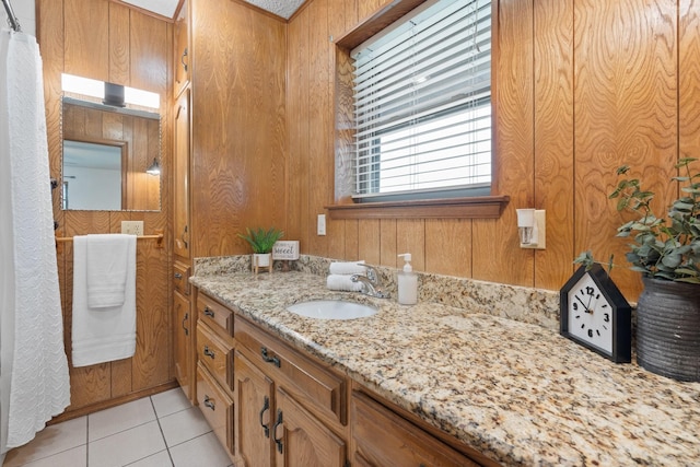 bathroom with vanity, wood walls, and tile patterned flooring