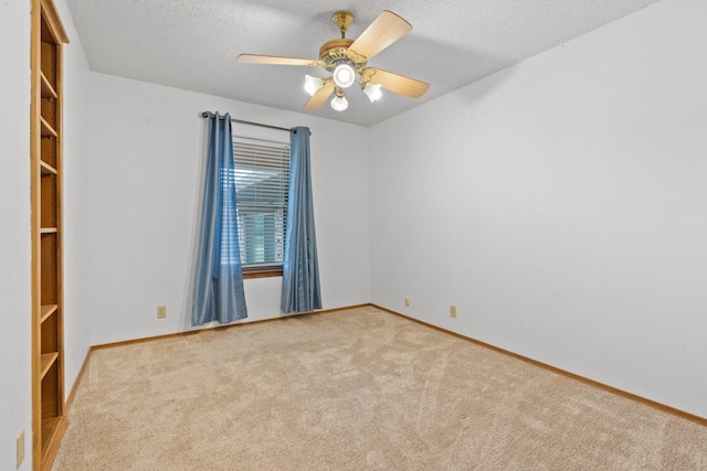 carpeted empty room with ceiling fan and a textured ceiling