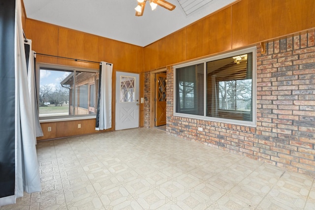 unfurnished sunroom featuring ceiling fan