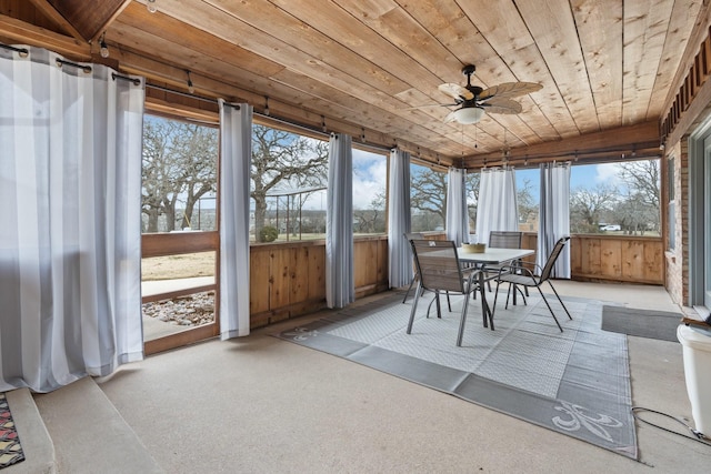 unfurnished sunroom with ceiling fan, plenty of natural light, and wood ceiling