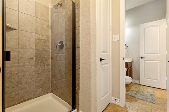 bathroom with a tile shower, toilet, tile patterned flooring, and vanity