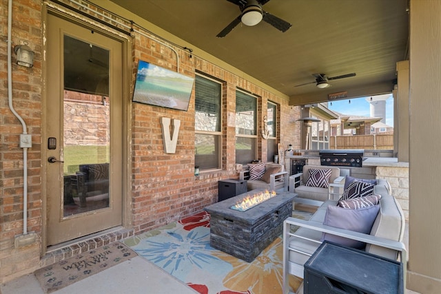 view of patio with a fire pit, ceiling fan, and area for grilling