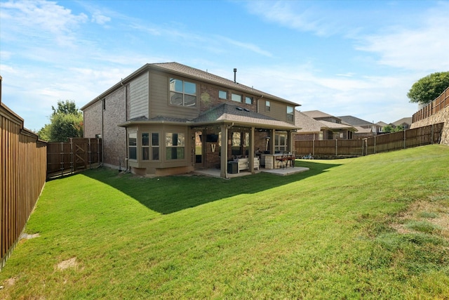 back of house with a patio area and a yard