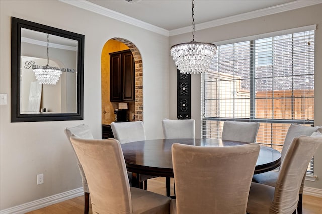 dining area featuring ornamental molding, a chandelier, and light hardwood / wood-style flooring