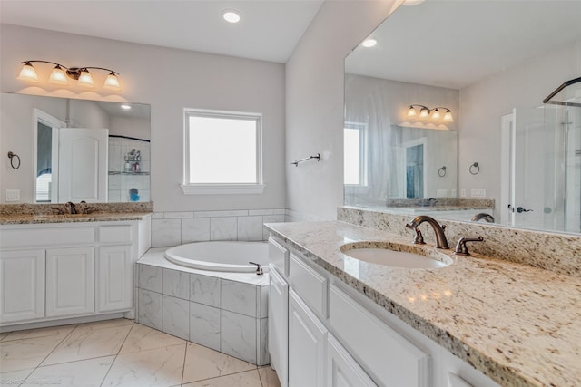 bathroom featuring a relaxing tiled tub and vanity