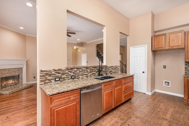 kitchen with light stone countertops, sink, stainless steel dishwasher, and dark wood-type flooring