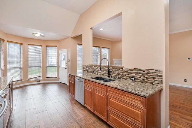 kitchen featuring vaulted ceiling, tasteful backsplash, dishwasher, sink, and light stone countertops