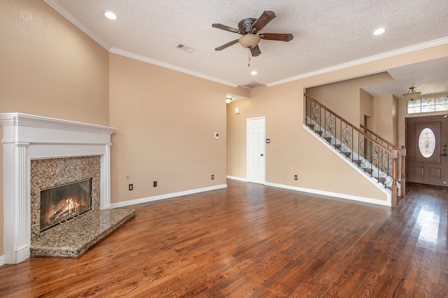 unfurnished living room with crown molding, wood-type flooring, a fireplace, and a textured ceiling