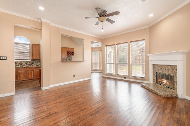 unfurnished living room with crown molding, a high end fireplace, dark hardwood / wood-style floors, and a textured ceiling