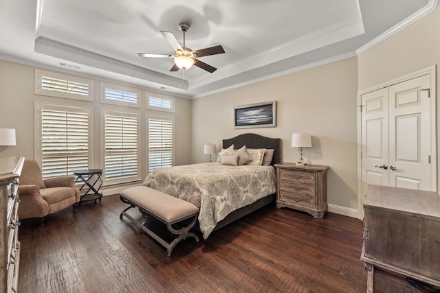 bedroom featuring a closet, ornamental molding, a raised ceiling, and ceiling fan