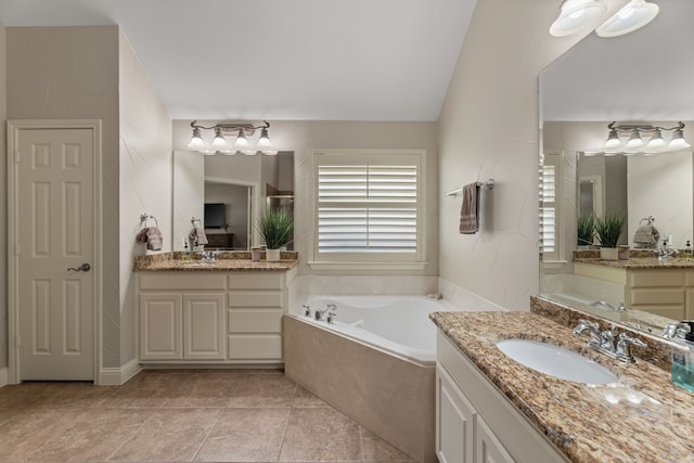 bathroom featuring vanity, lofted ceiling, tile patterned floors, and a relaxing tiled tub