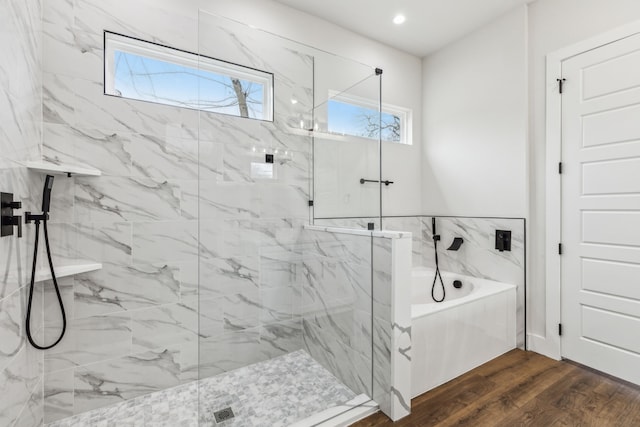 bathroom with independent shower and bath and hardwood / wood-style floors