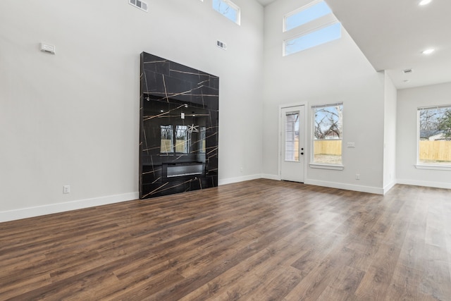 unfurnished living room with a high ceiling and hardwood / wood-style floors