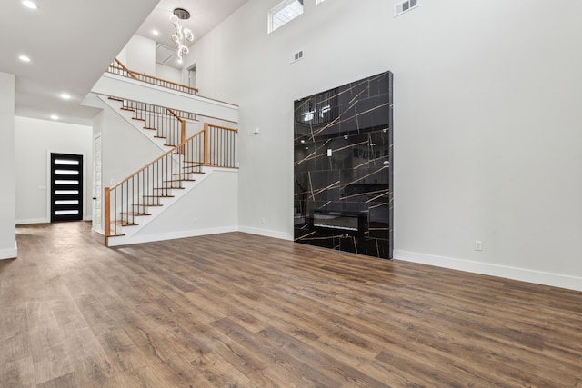 foyer entrance featuring a high ceiling, wood-type flooring, and a notable chandelier