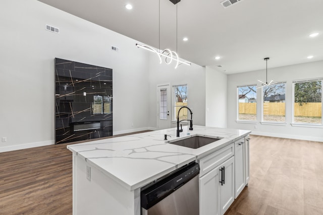 kitchen featuring white cabinets, an island with sink, sink, hanging light fixtures, and stainless steel dishwasher