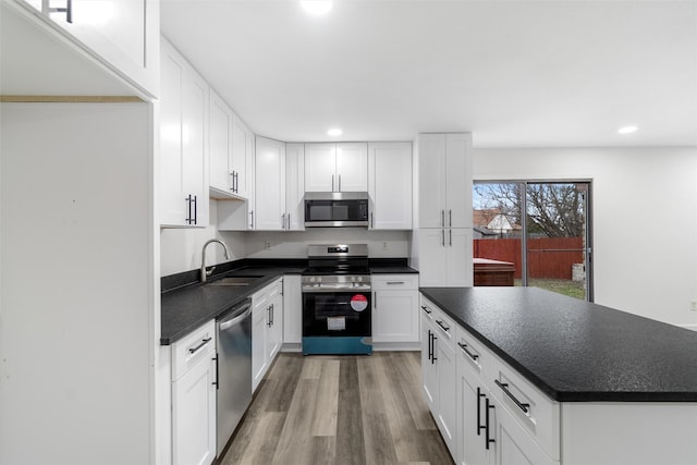 kitchen featuring light hardwood / wood-style floors, sink, white cabinets, and appliances with stainless steel finishes