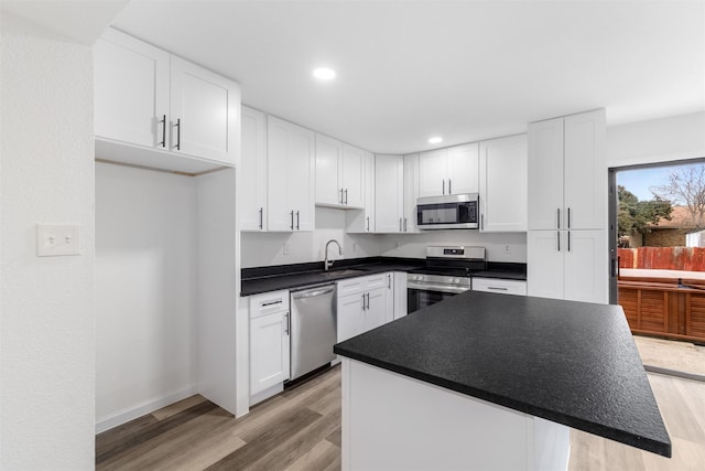 kitchen featuring white cabinets, light hardwood / wood-style flooring, appliances with stainless steel finishes, and sink