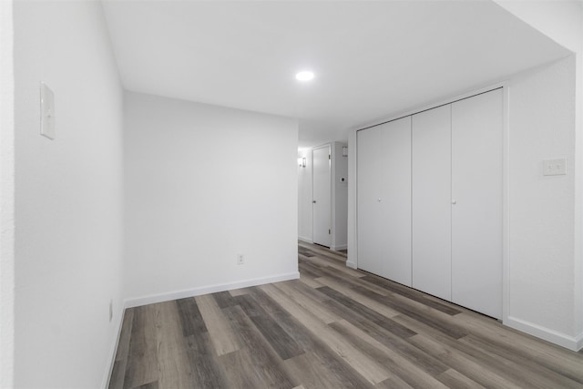 unfurnished bedroom featuring hardwood / wood-style flooring and a closet