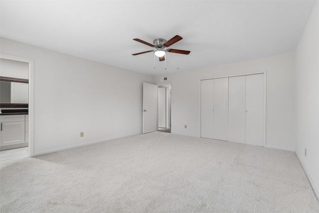 unfurnished bedroom with a closet, ceiling fan, and light carpet