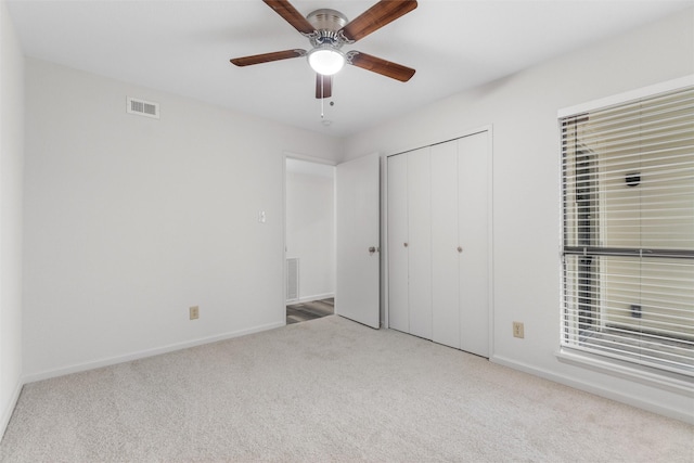 unfurnished bedroom with light carpet, ceiling fan, and a closet