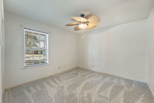 carpeted spare room featuring ceiling fan