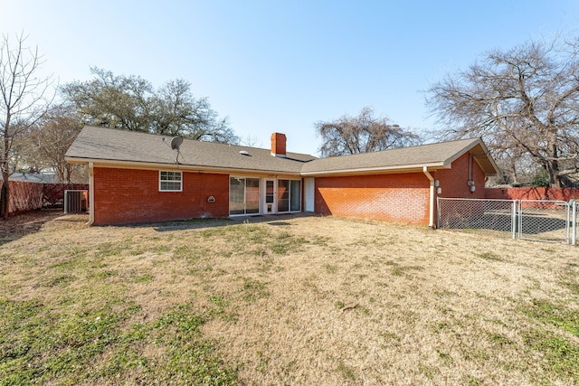 back of property featuring central AC unit and a lawn