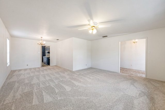 unfurnished living room with ceiling fan with notable chandelier and light colored carpet