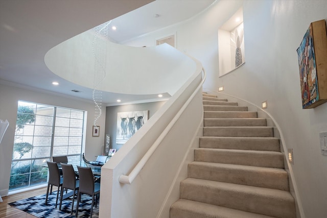 stairway with hardwood / wood-style floors and ornamental molding