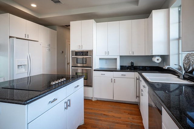 kitchen featuring sink, white cabinets, dark stone counters, and appliances with stainless steel finishes