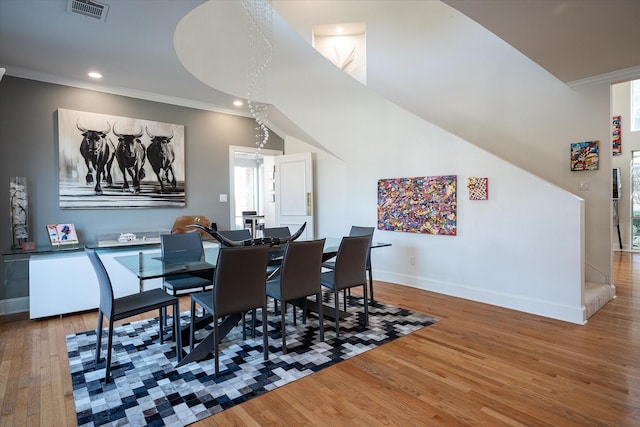 dining area with hardwood / wood-style floors and crown molding